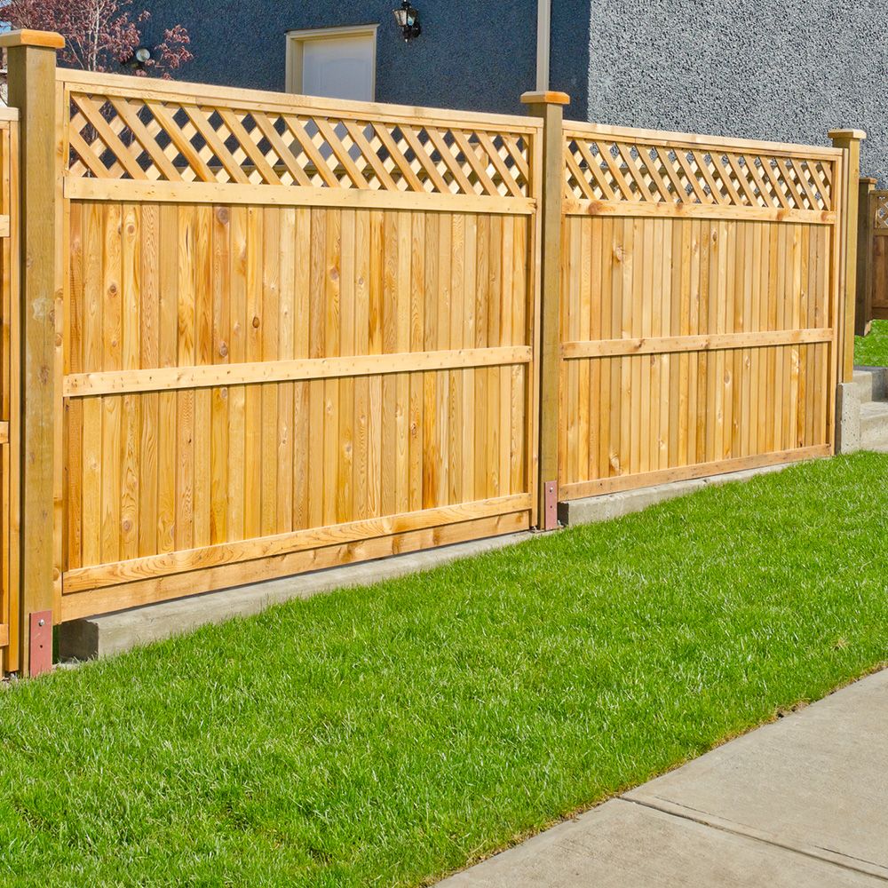 Ein grüner Rasen mit einem Holzzaun